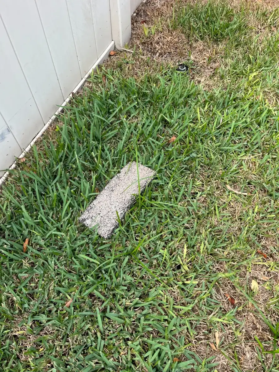 Shingle blown off a roof and lying in the yard after a storm