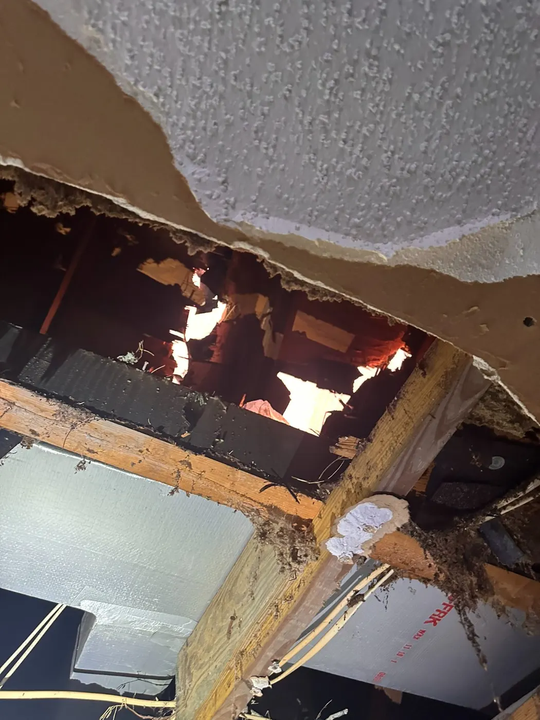Hurricane roof breach visible through an opened ceiling