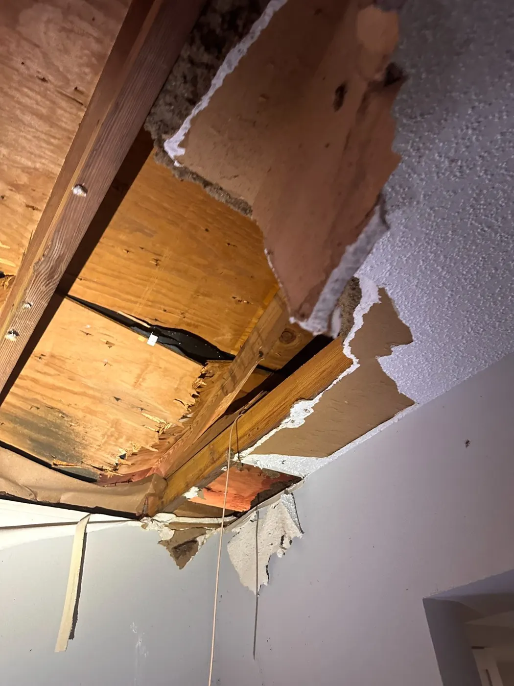 Water-damaged ceiling drywall and roof decking above